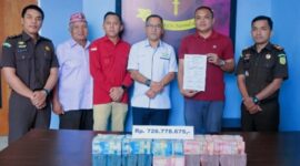 Heribert Aswin Muriadi Mahu (kaos merah), anak terpidana kasus korupsi proyek tong sampah Yustinus Mahu, saat menyerahkan uang pengganti ratusan juta di Kantor Kejaksaan Negeri Manggarai pada 22 Oktober 2025. (Dok: Kejari Manggarai)