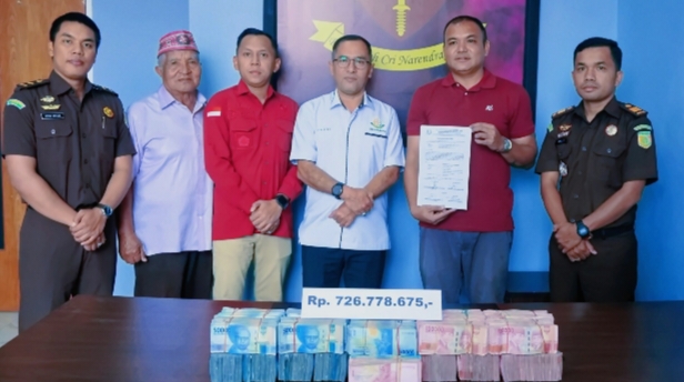 Heribert Aswin Muriadi Mahu (kaos merah), anak terpidana kasus korupsi proyek tong sampah Yustinus Mahu, saat menyerahkan uang pengganti ratusan juta di Kantor Kejaksaan Negeri Manggarai pada 22 Oktober 2025. (Dok: Kejari Manggarai)